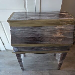 Glass trinket boxes individually wrapped and secured upright inside divider crates.