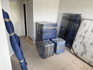 Wrapped reading table being moved by Calgary movers through a recessed hallway.