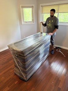 Wrapped display cabinet being moved carefully by professional movers in Montreal.