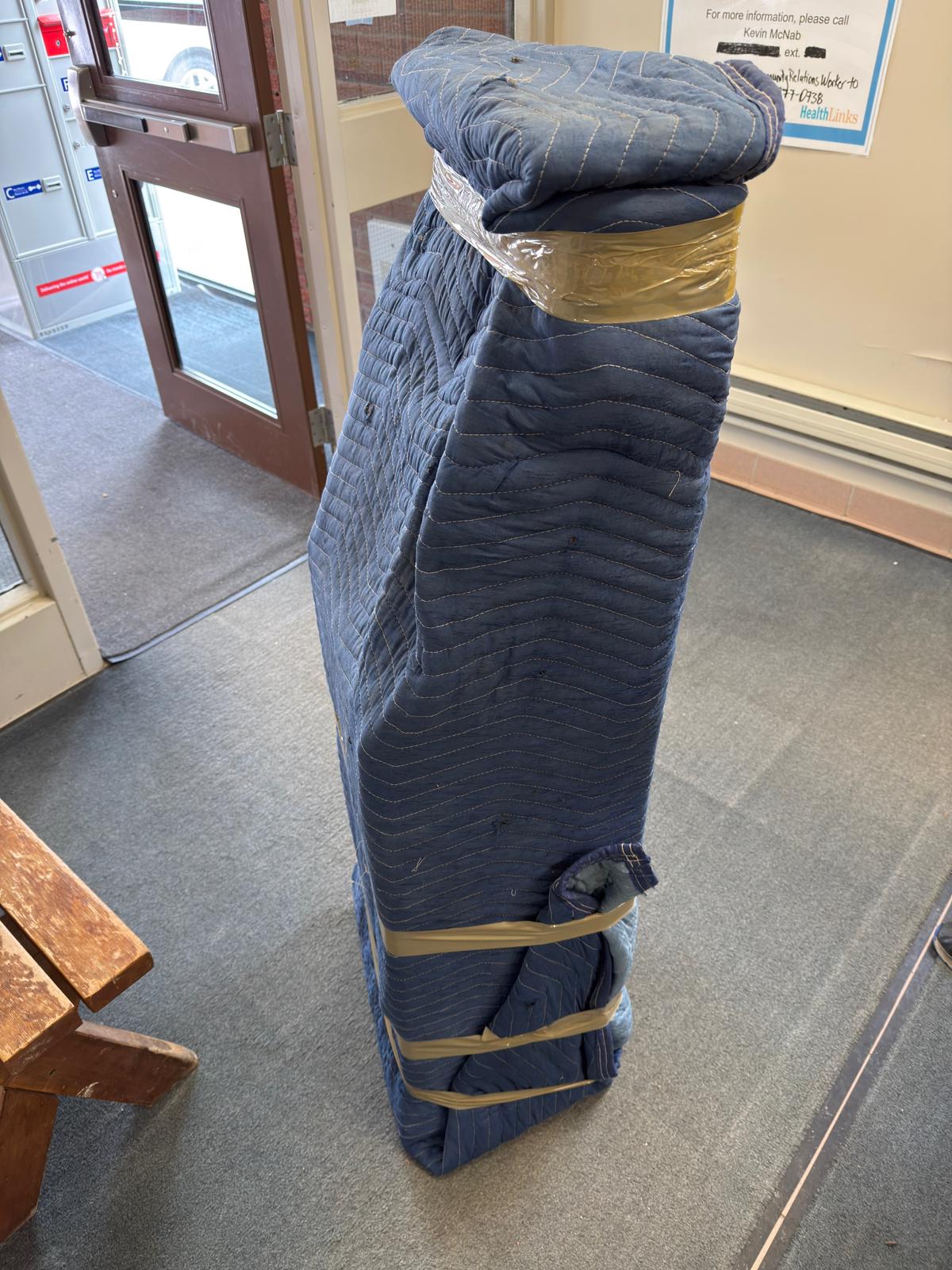 Protective floor runners placed along the exit pathway during a professional apartment move in Montreal.