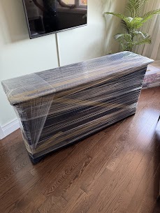 Movers carefully preparing a wooden hutch for a home move from Old Toronto to Regent Park, ensuring safe transit.