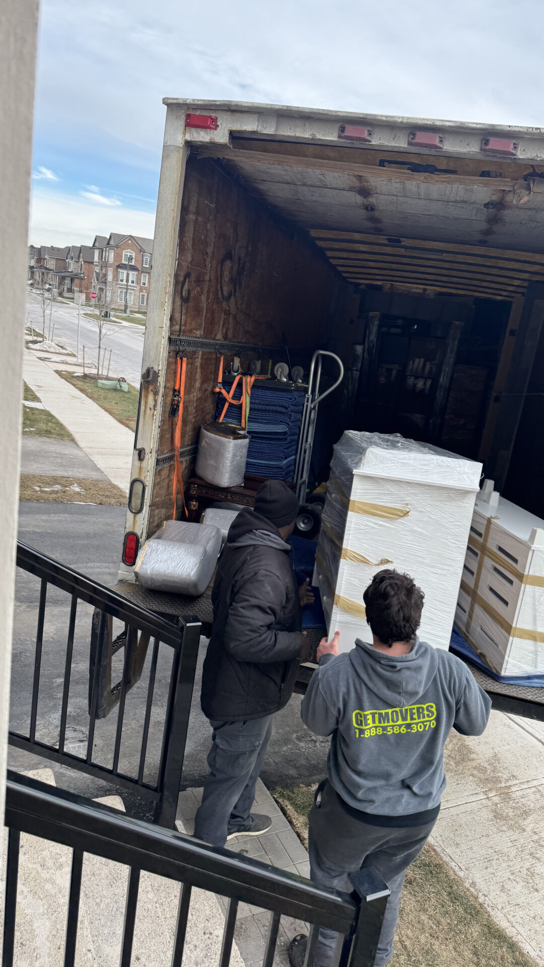 Movers placing furniture in the new Sunnylea living room.
