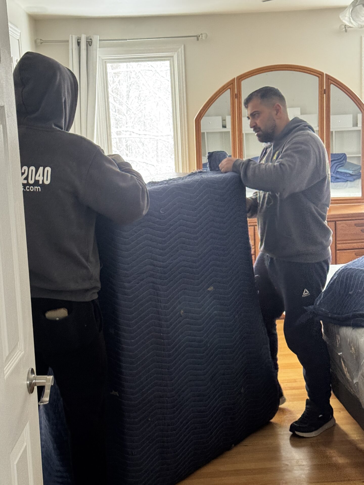 Professional movers maintaining clear pathways during the loading process in an Osborne Village home.