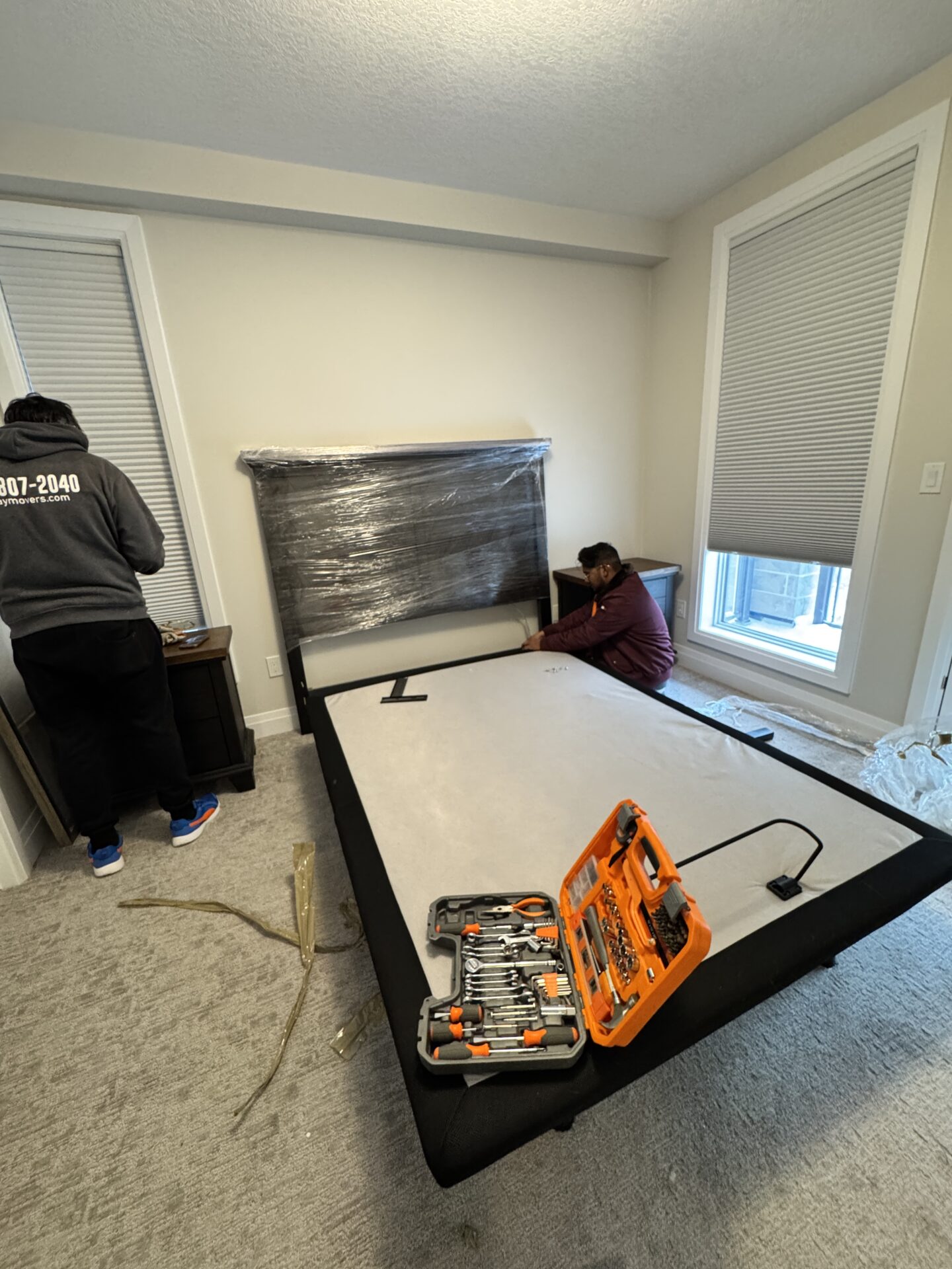 Professional movers maintaining clear pathways during the loading process in a West End home.