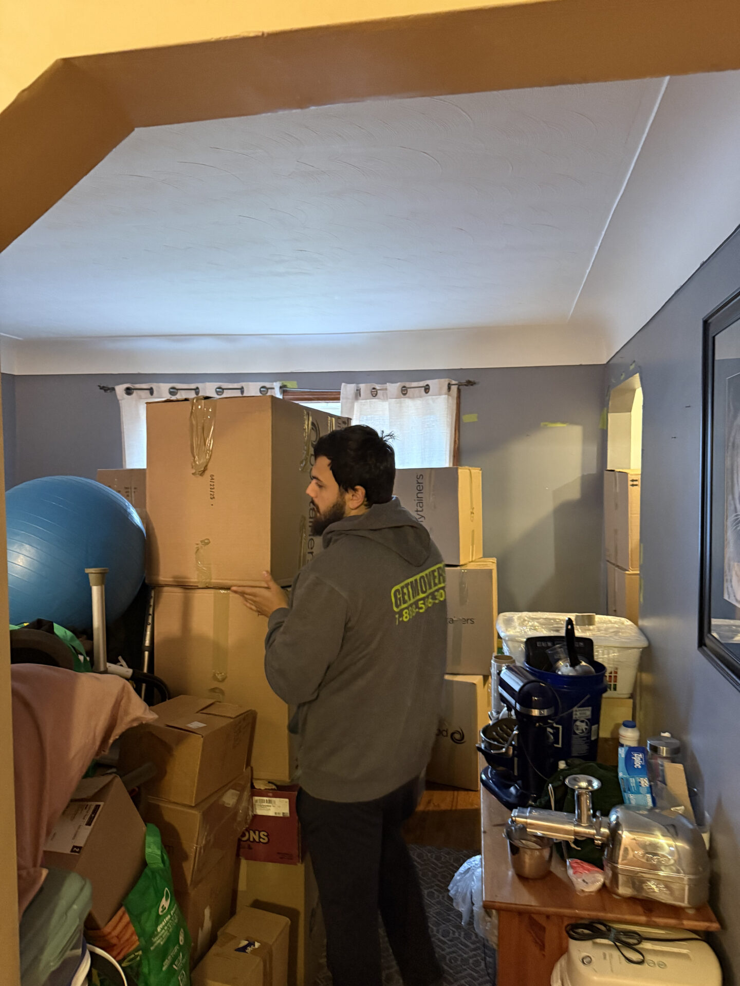Professional movers maintaining clear pathways during the loading process in a Whalley home.