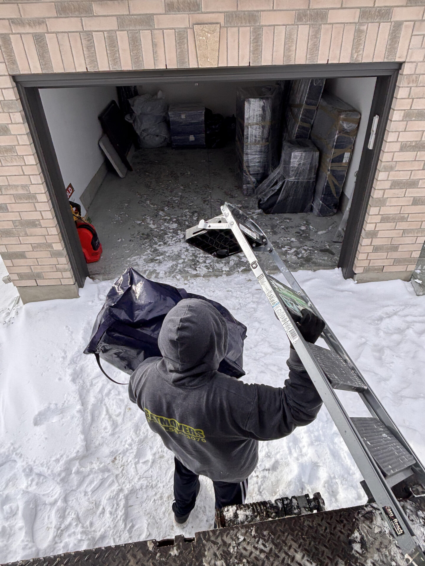 Professional movers maintaining clear pathways during the loading process in a Downtown Hamilton home.