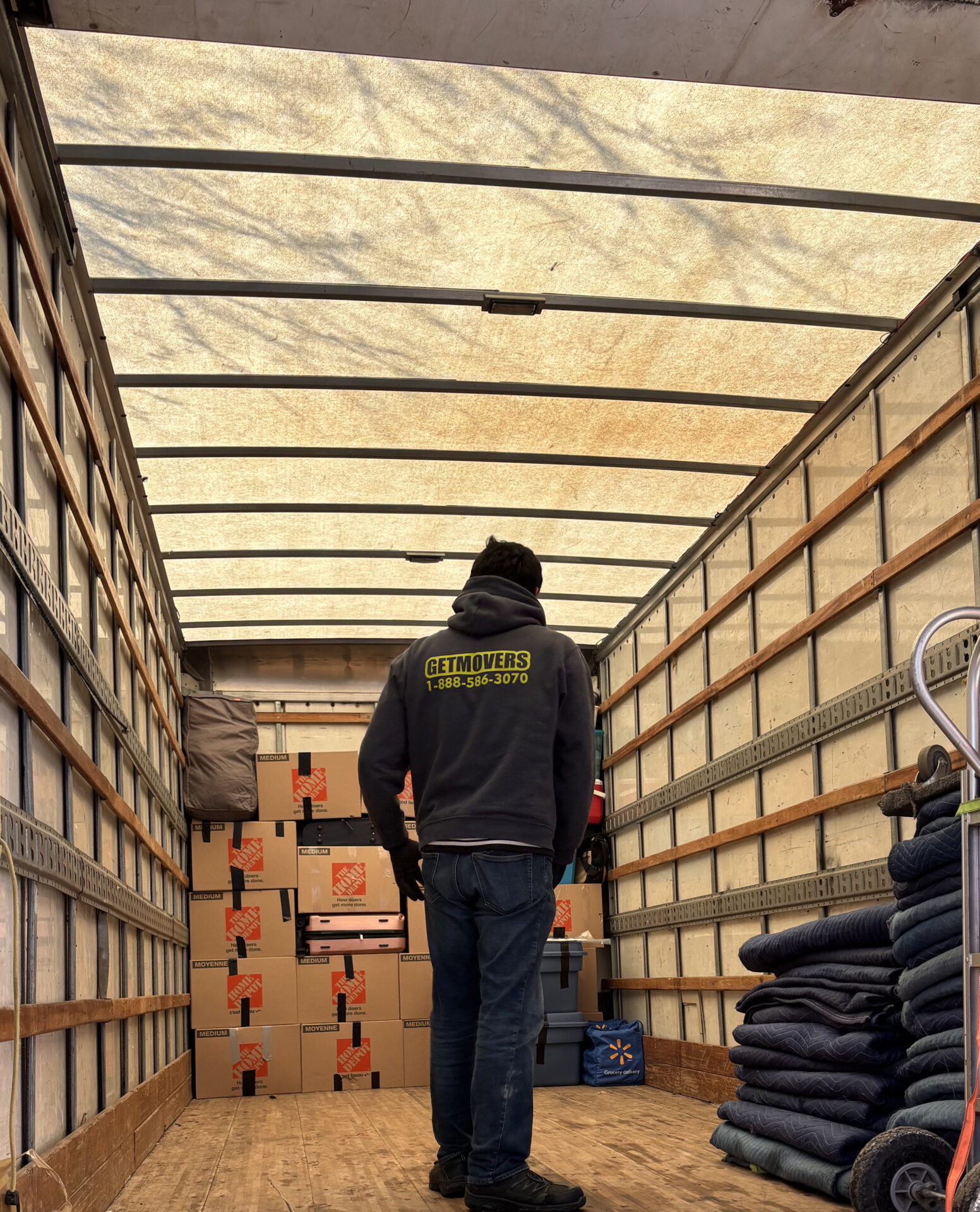 Professional movers maintaining clear pathways during the loading process in a Garneau home.