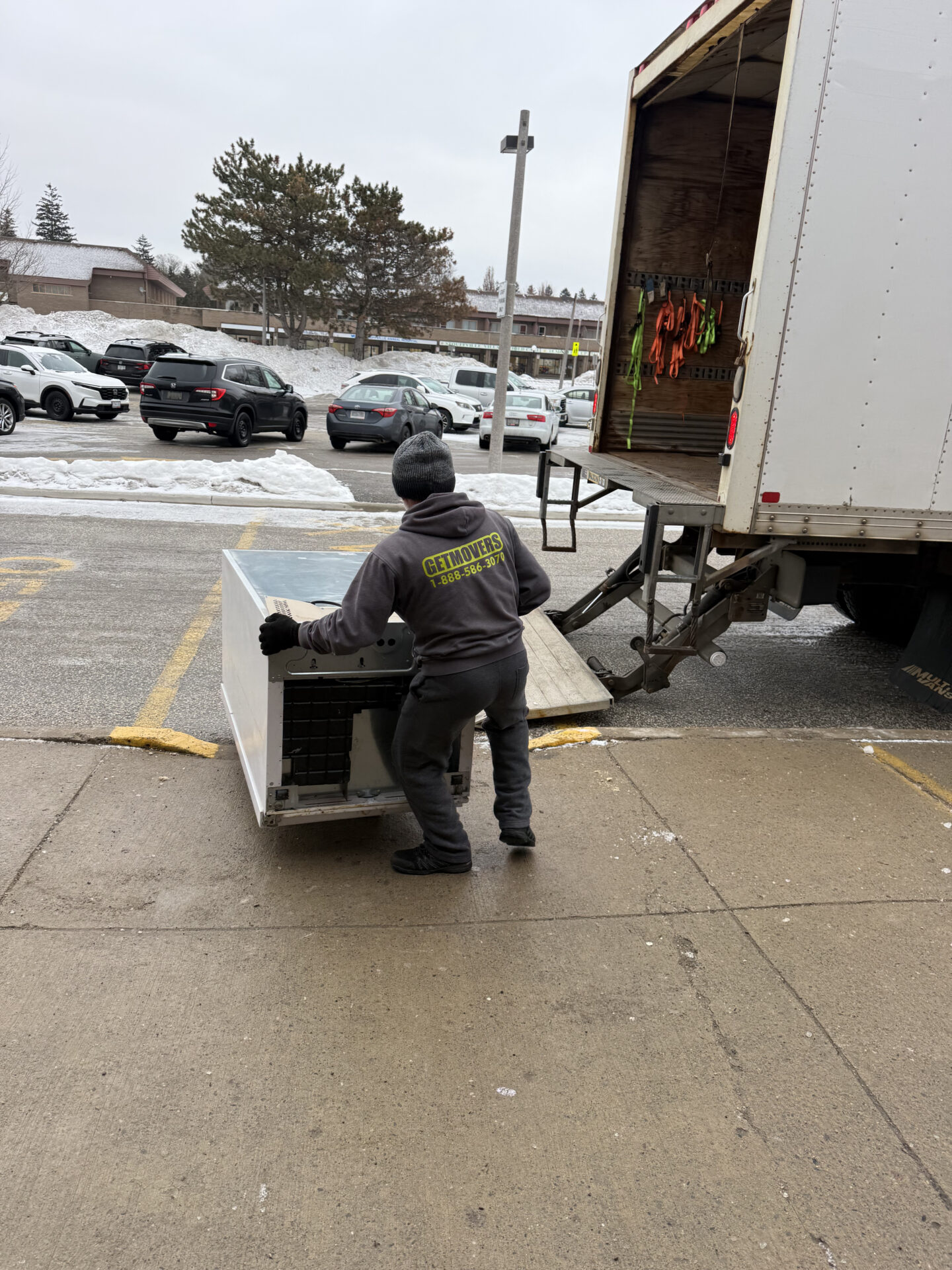 Movers maintaining a clear and safe path through the snow for loading.