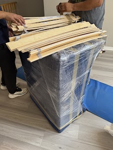 Moving truck positioned for loading in snowy winter conditions.