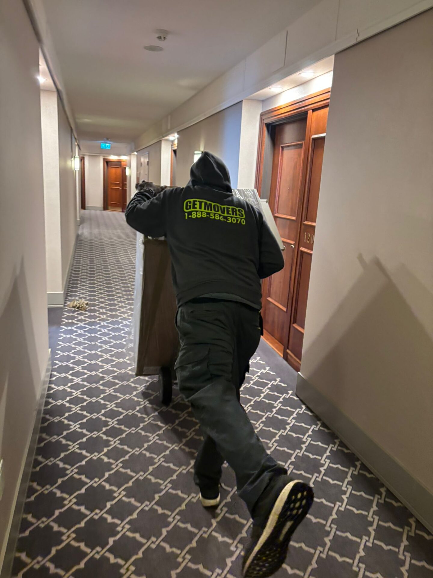 Professional movers maintaining clear pathways during the loading process in a Hamilton home.