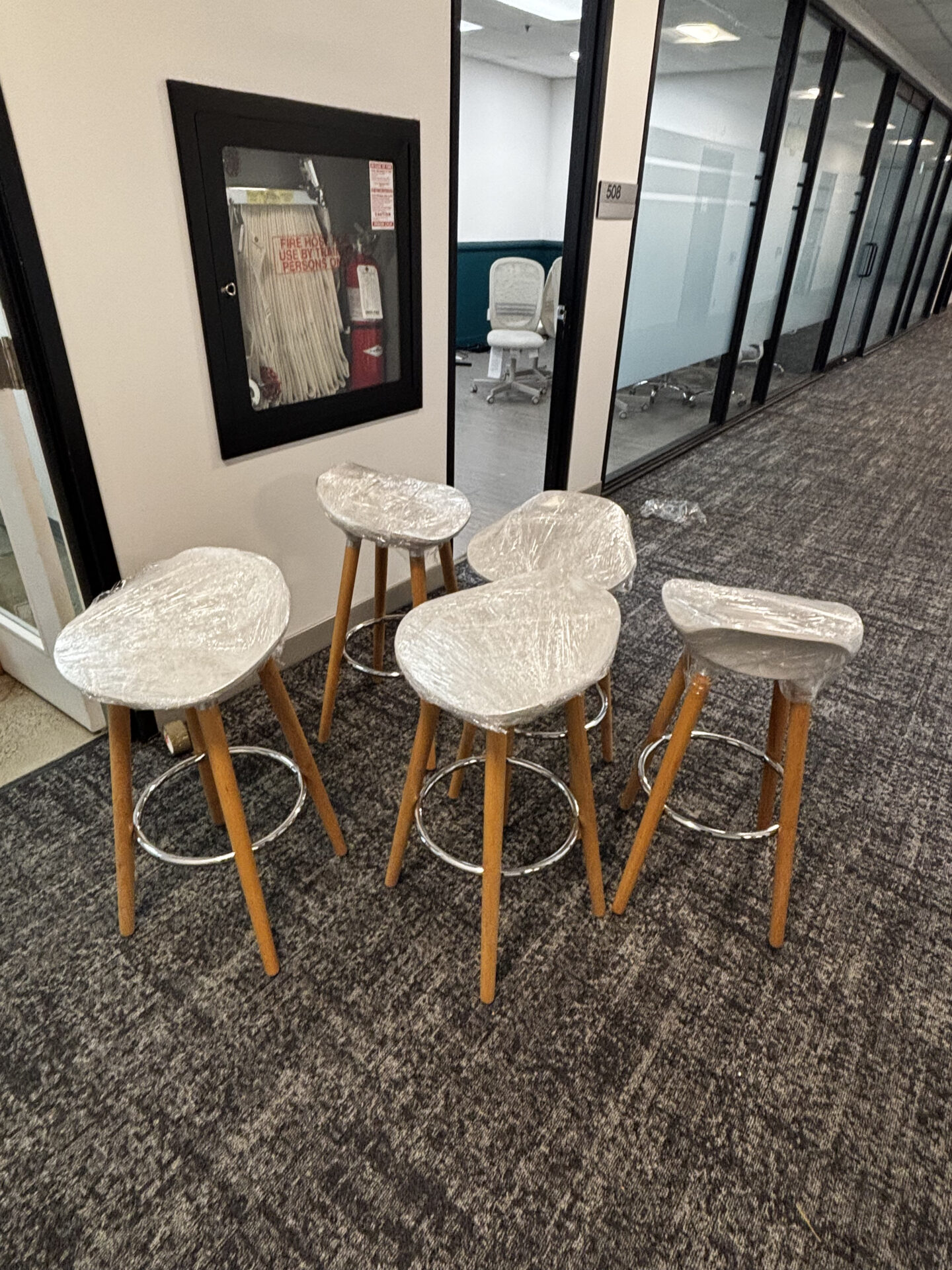 Movers using a lift-and-pivot technique to move a tall wooden console through a narrow hallway.