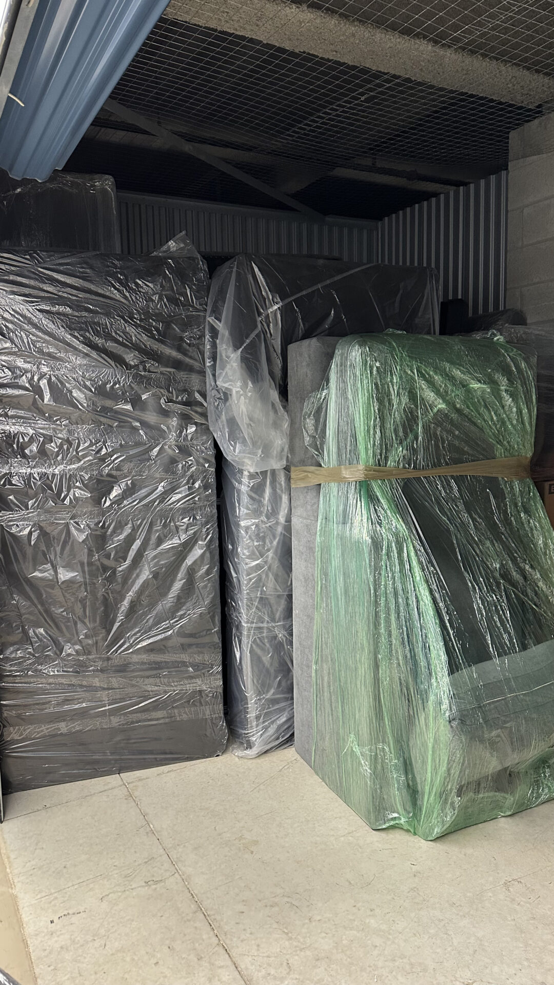 Movers wrapping furniture in walk-up apartment