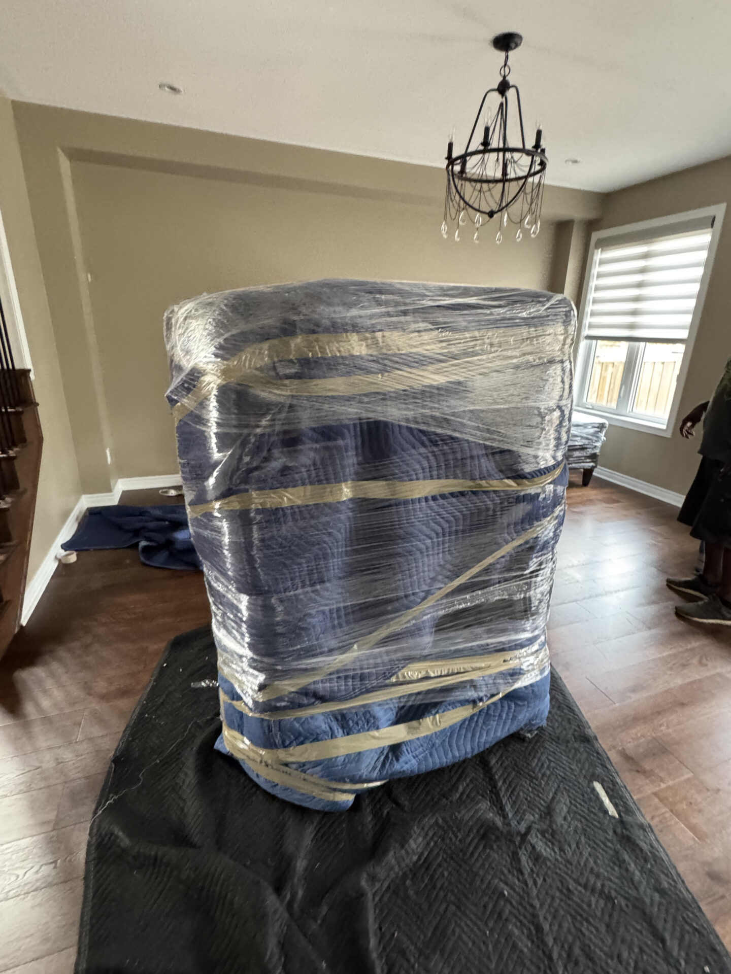 Movers wrapping heavy furniture for safe transport