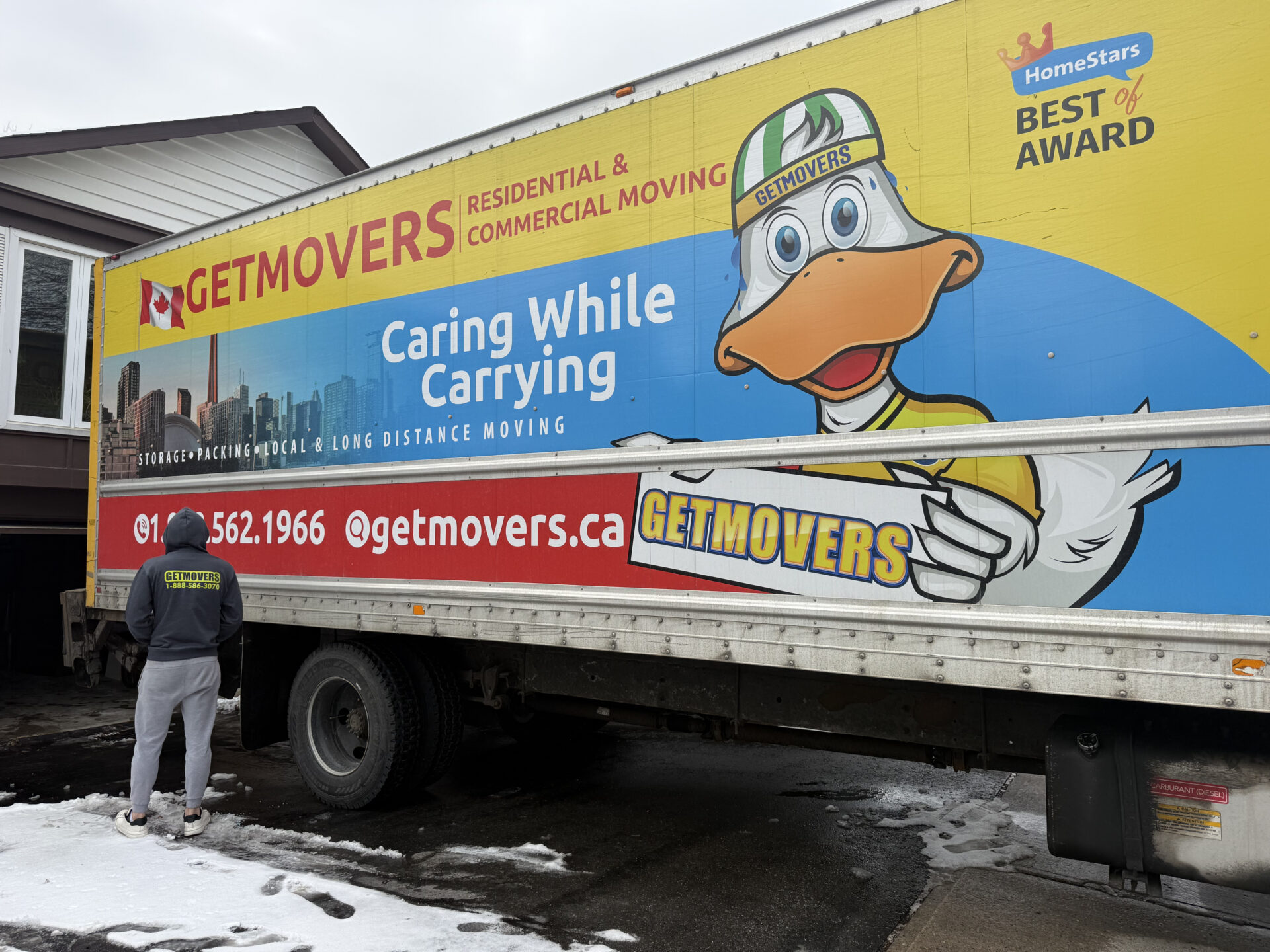 Crew loading moving truck from gravel driveway