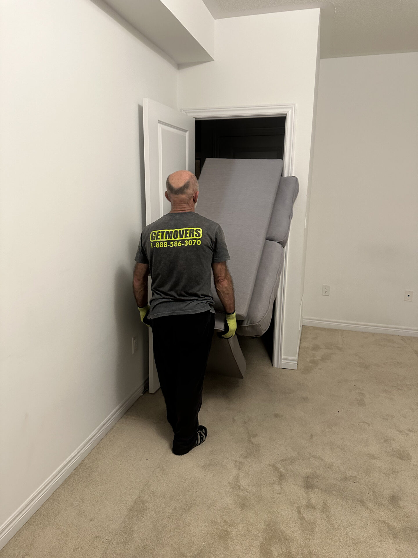 Movers using professional lifting technique at waterfront home
